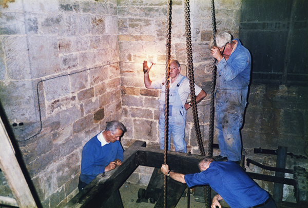 Chain lifting the bell from below up to the frame