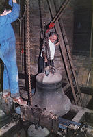 ﻿Bell being lifted through the frame in the belfry