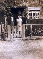 Mrs Jennings, postmistress outside the Post Office